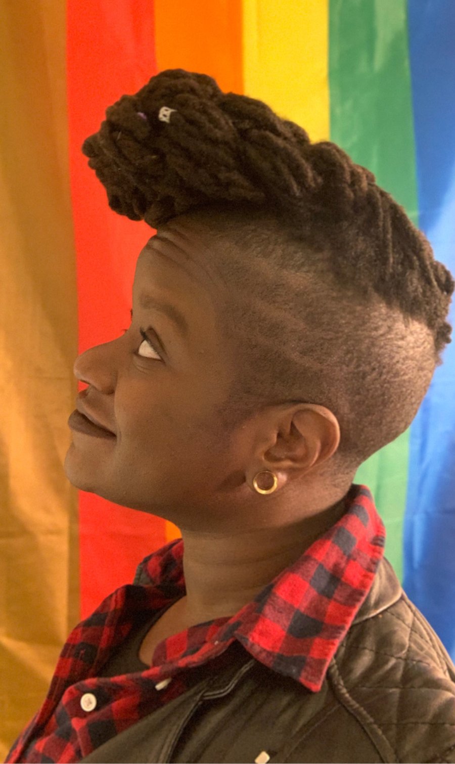 Chinyere Ezie, founder of Baddie Be Well, in front of a Pride flag